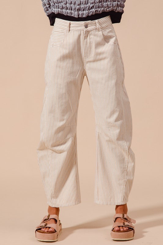 A model wearing mid-rise pinstripe barrel trousers with a relaxed fit and pockets on the side.