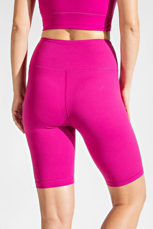 a woman in a pink sports bra top and shorts