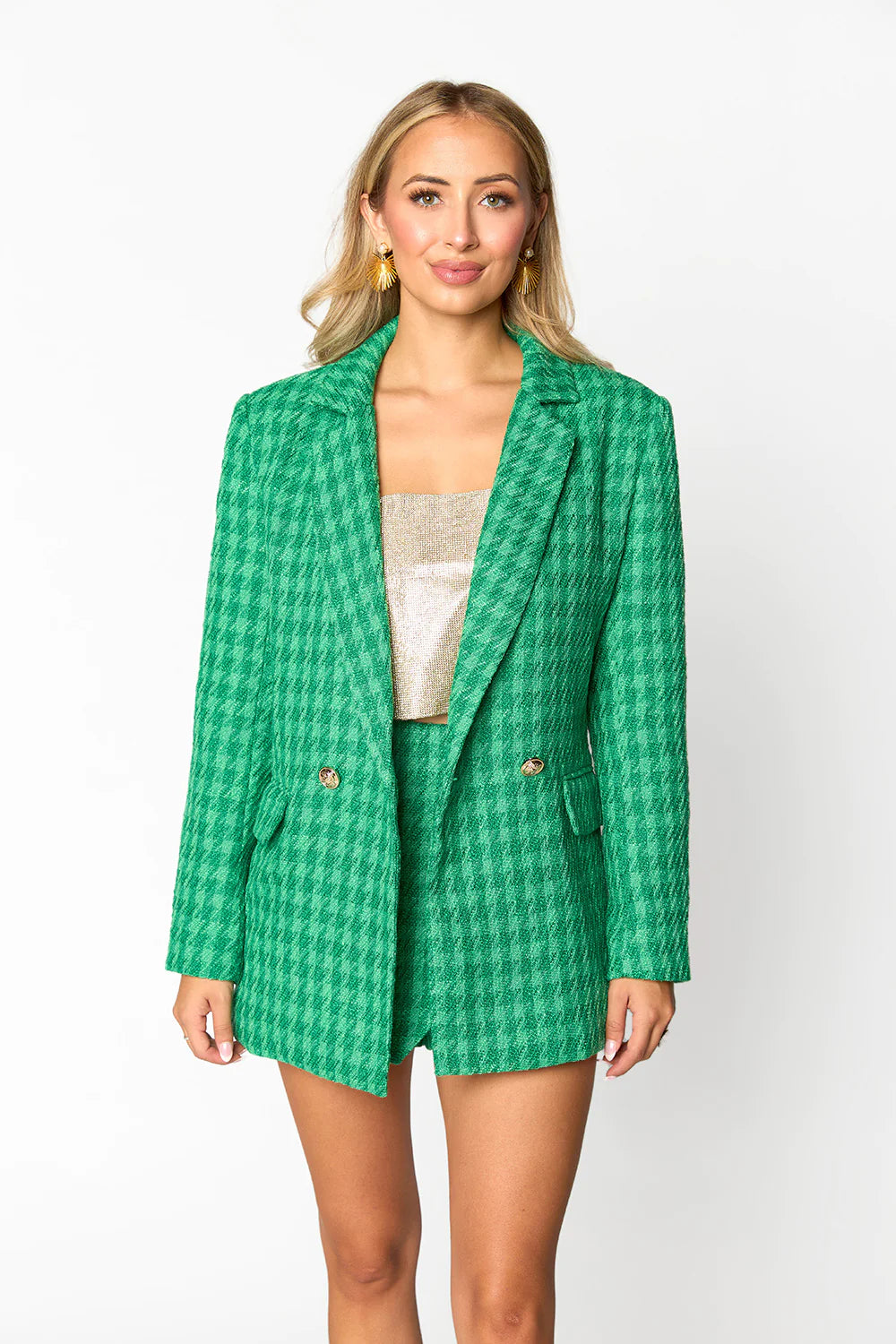 a woman wearing a green jacket and shorts