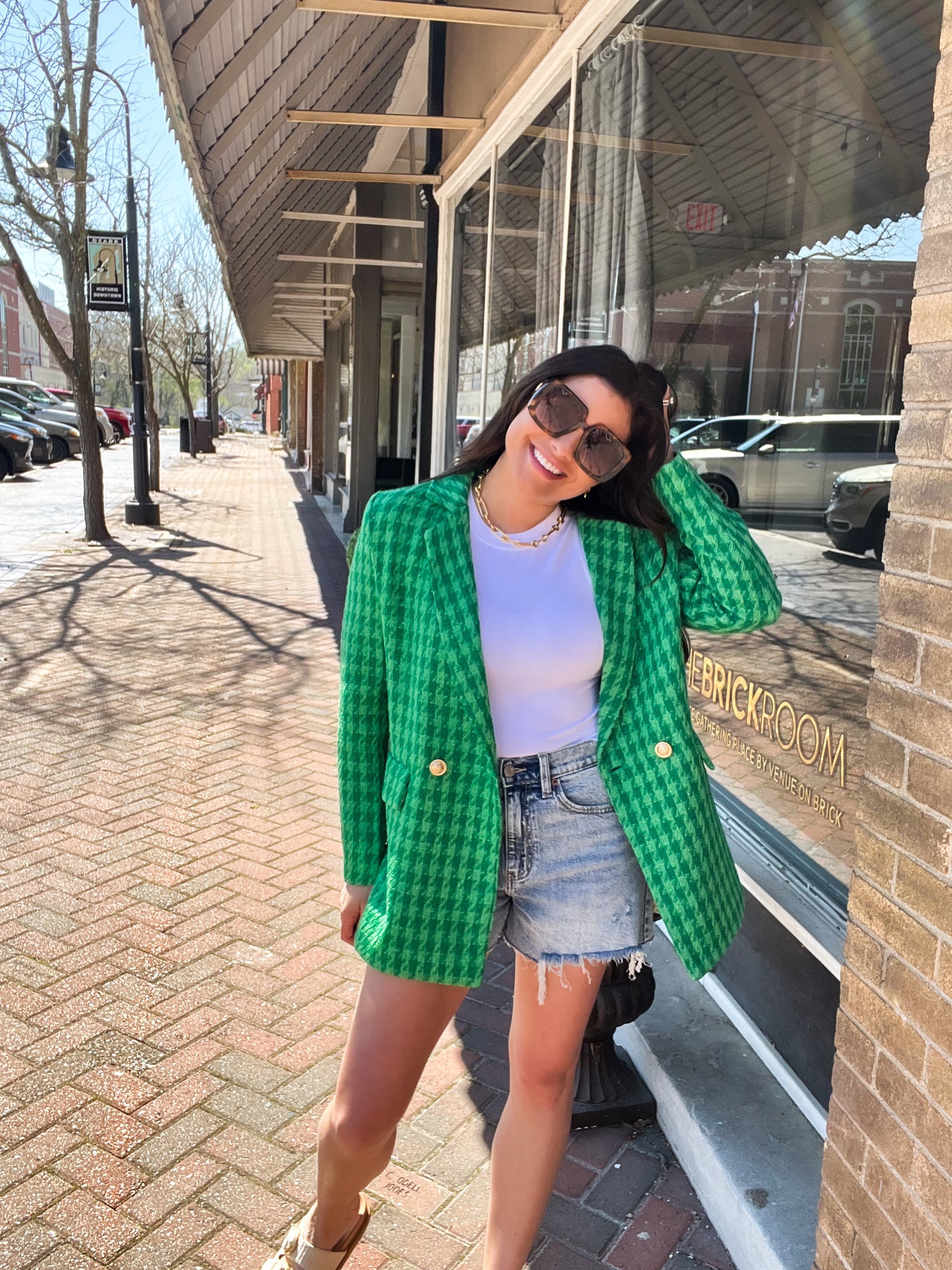 a woman in a green jacket is posing for a picture