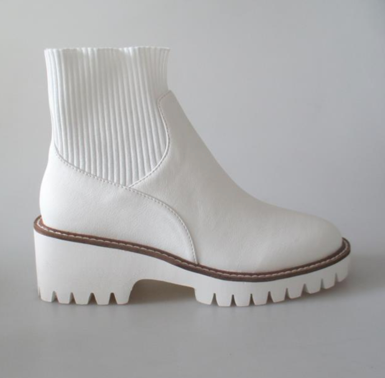a pair of white boots sitting on top of a white floor