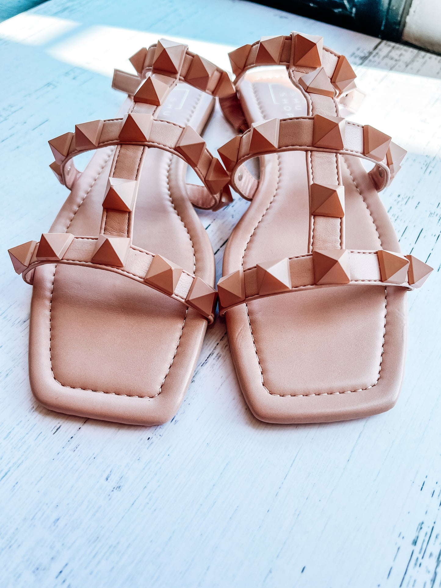 a pair of pink sandals sitting on top of a white table