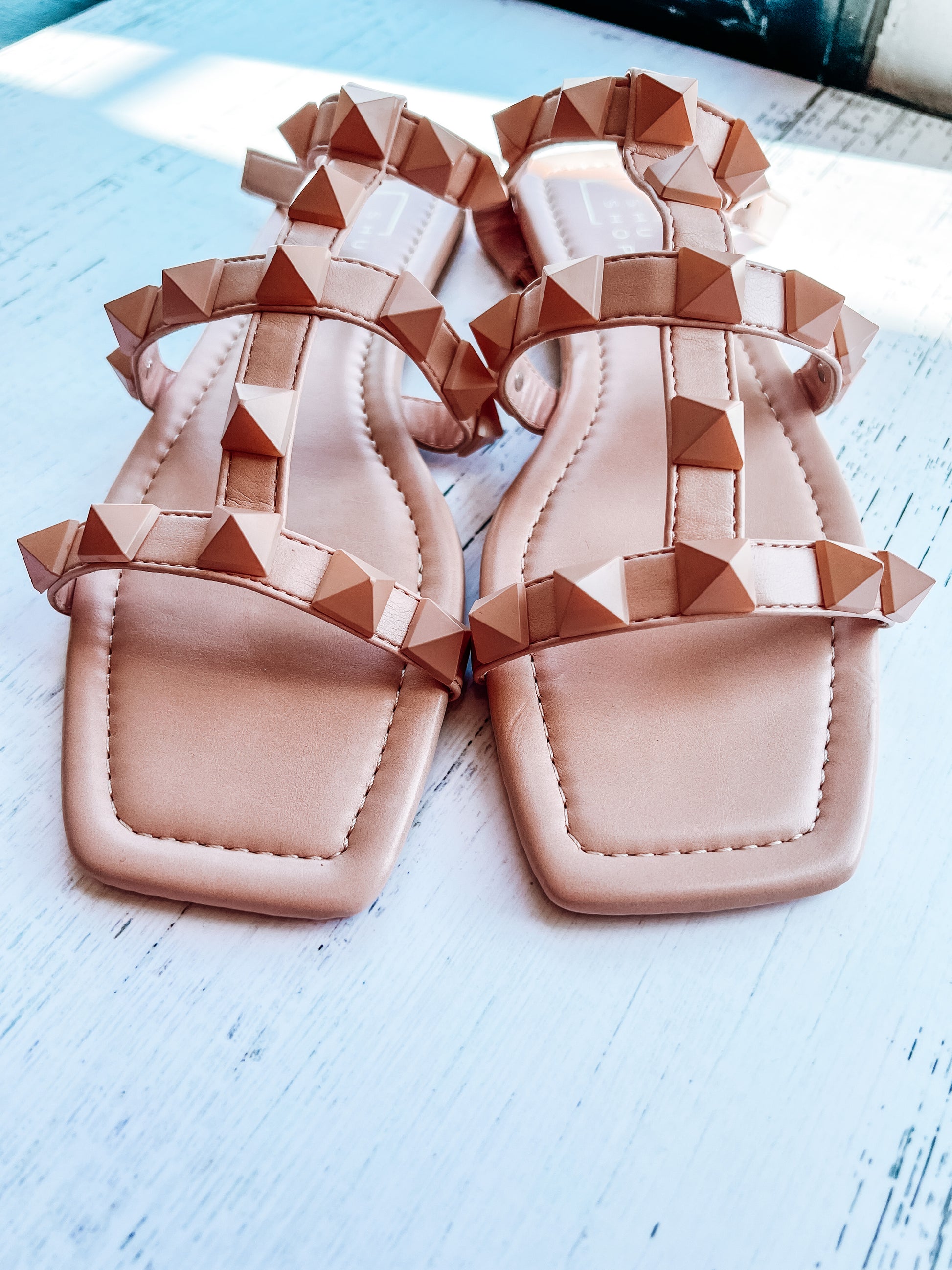 a pair of pink sandals sitting on top of a white table
