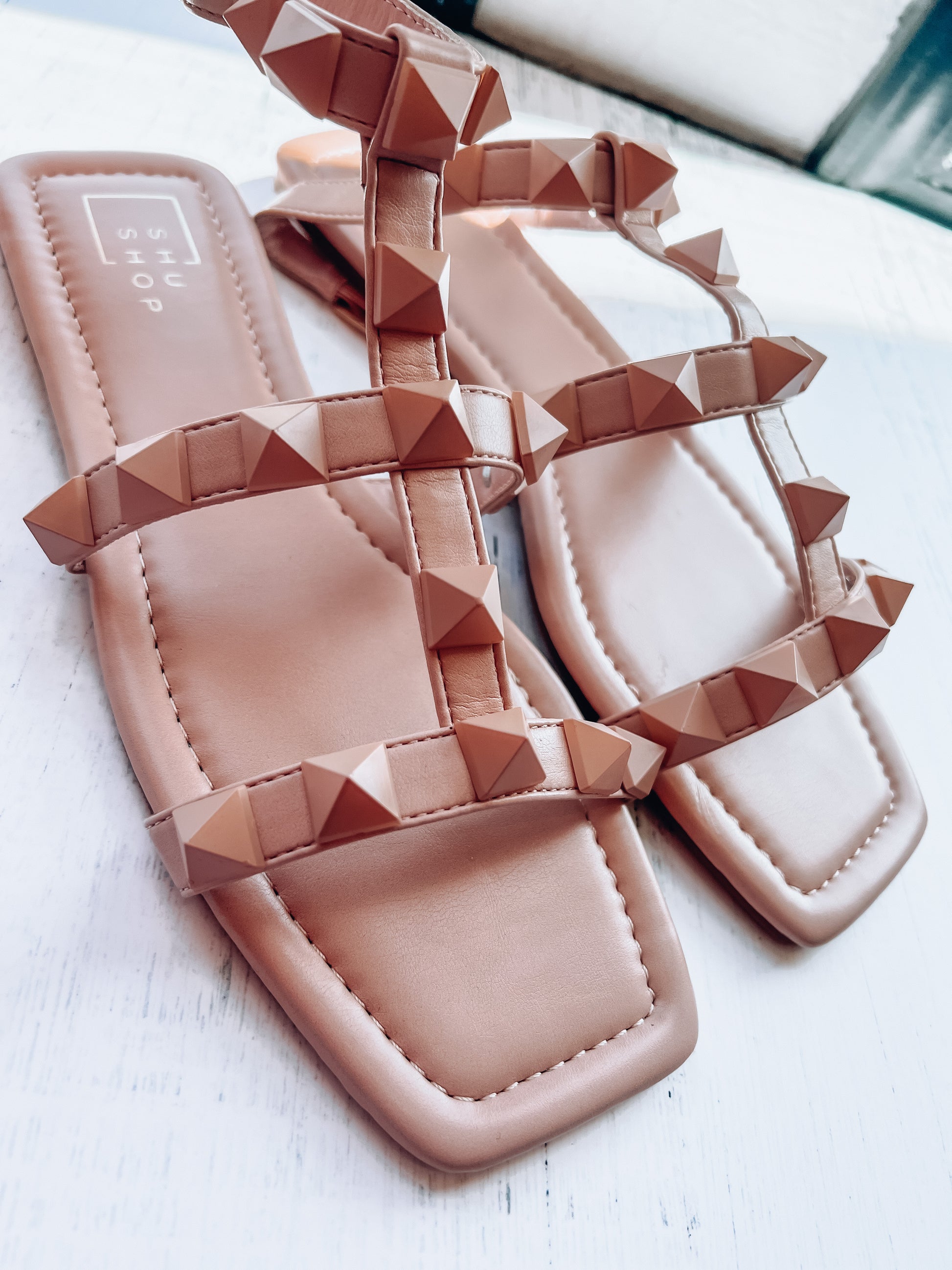 a pair of pink sandals sitting on top of a white table