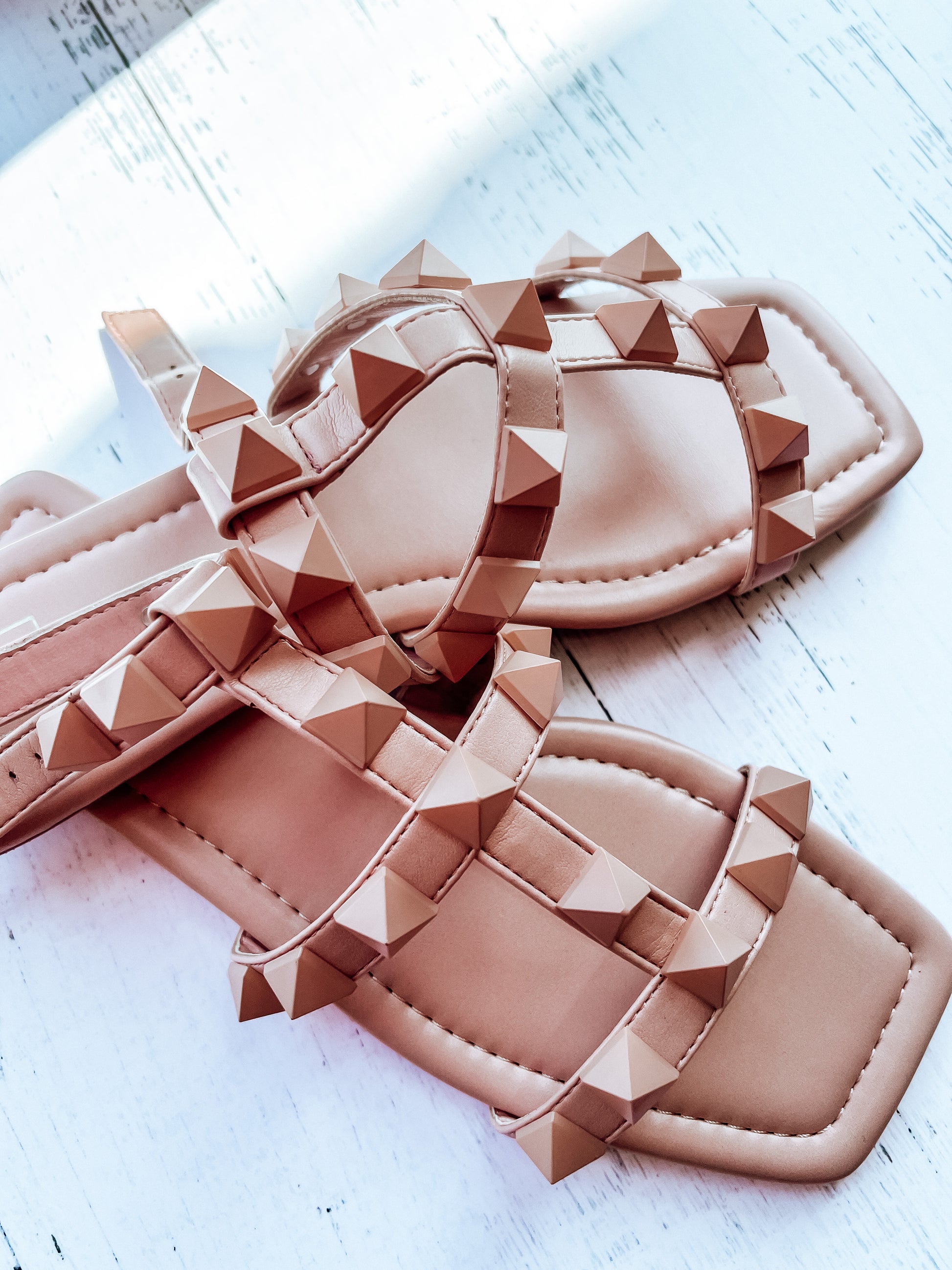 a pair of pink sandals sitting on top of a white table
