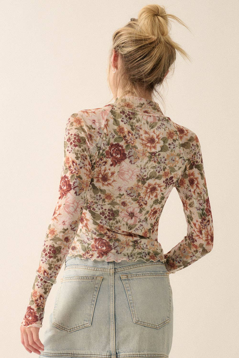 a woman wearing a floral shirt and denim skirt