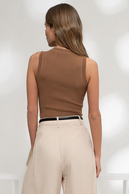 a woman in a brown top and beige pants