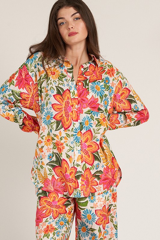 a woman in a colorful floral print shirt and pants