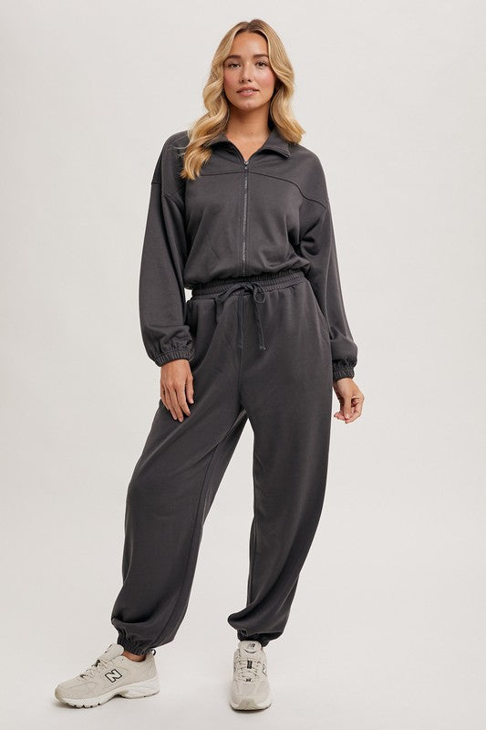 a woman in grey jumpsuits and sneakers