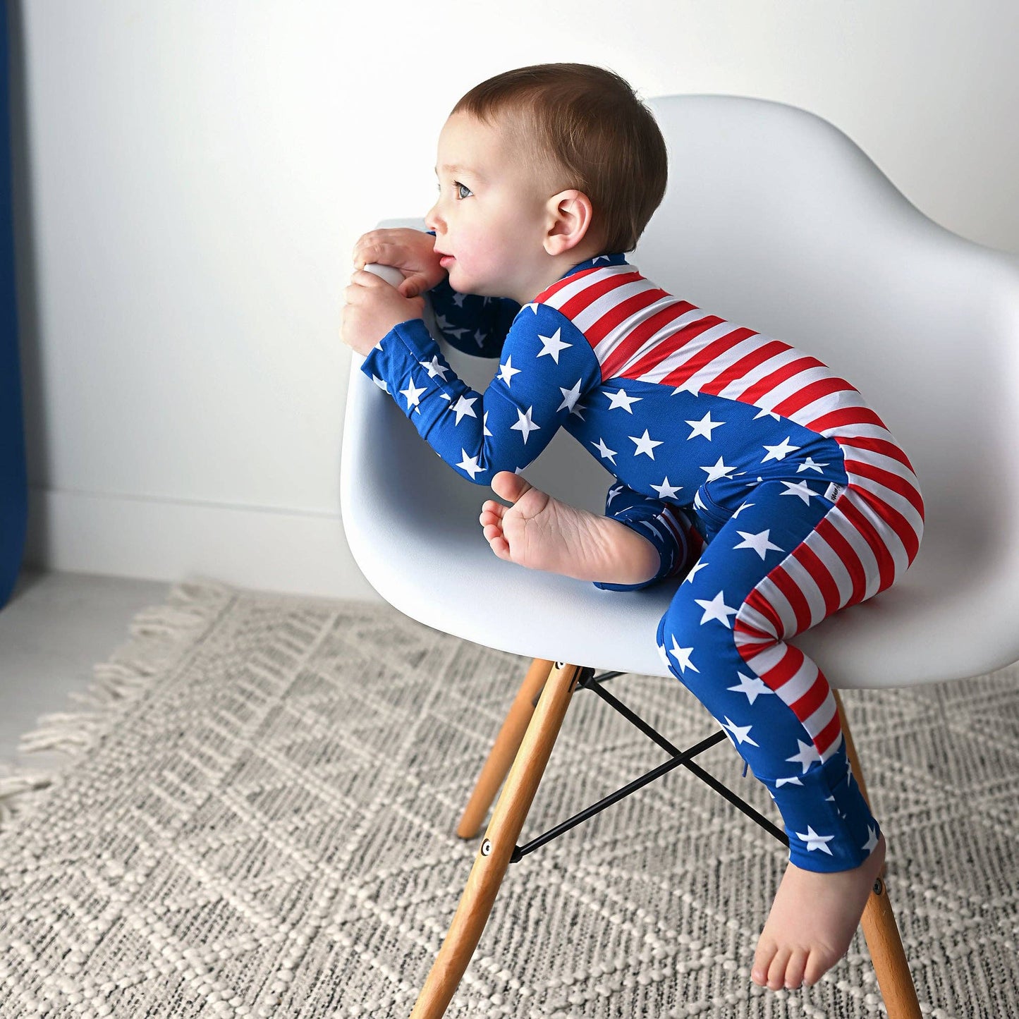 a baby sitting on a chair eating a donut