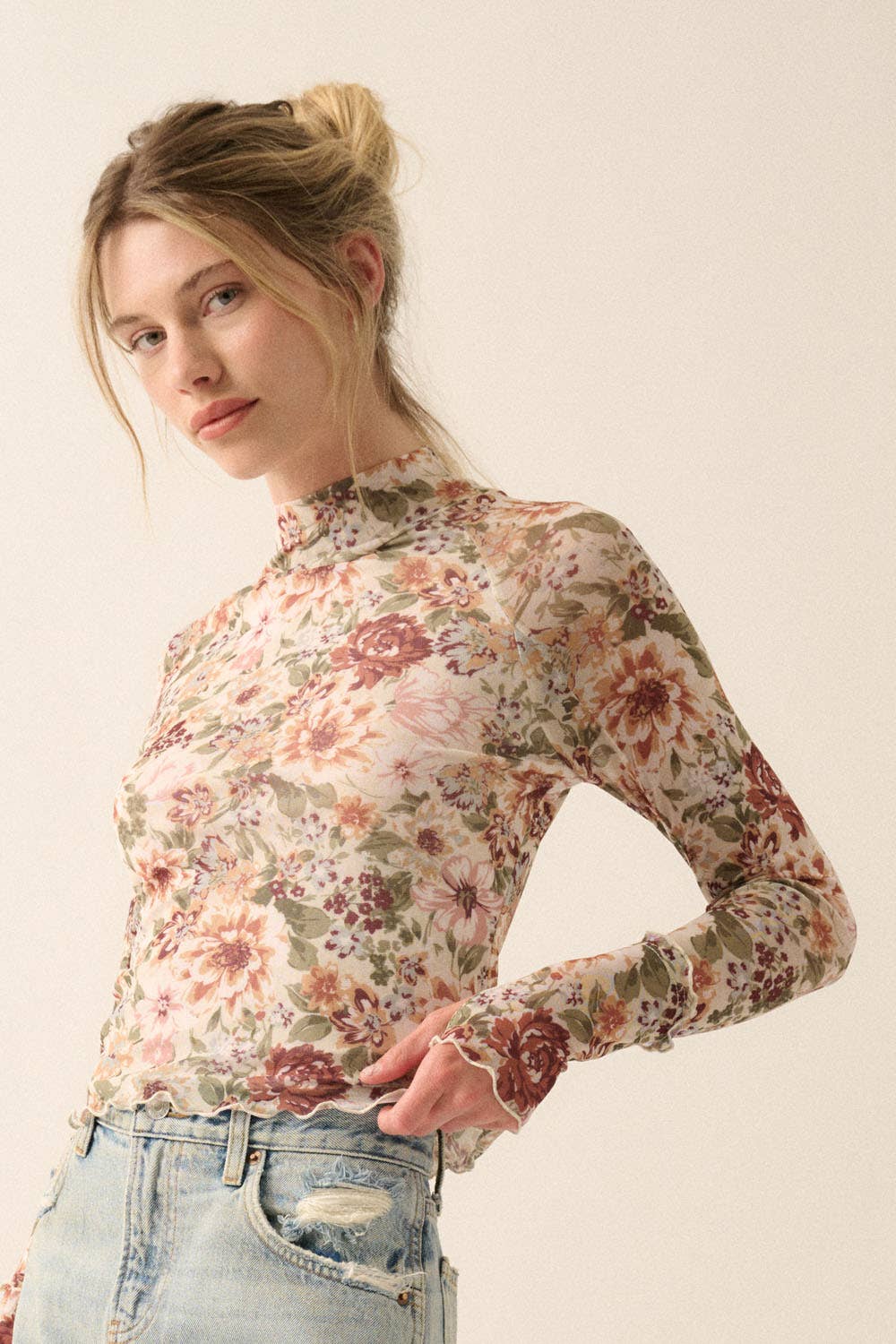 a woman in a floral shirt is standing with her hands on her hips