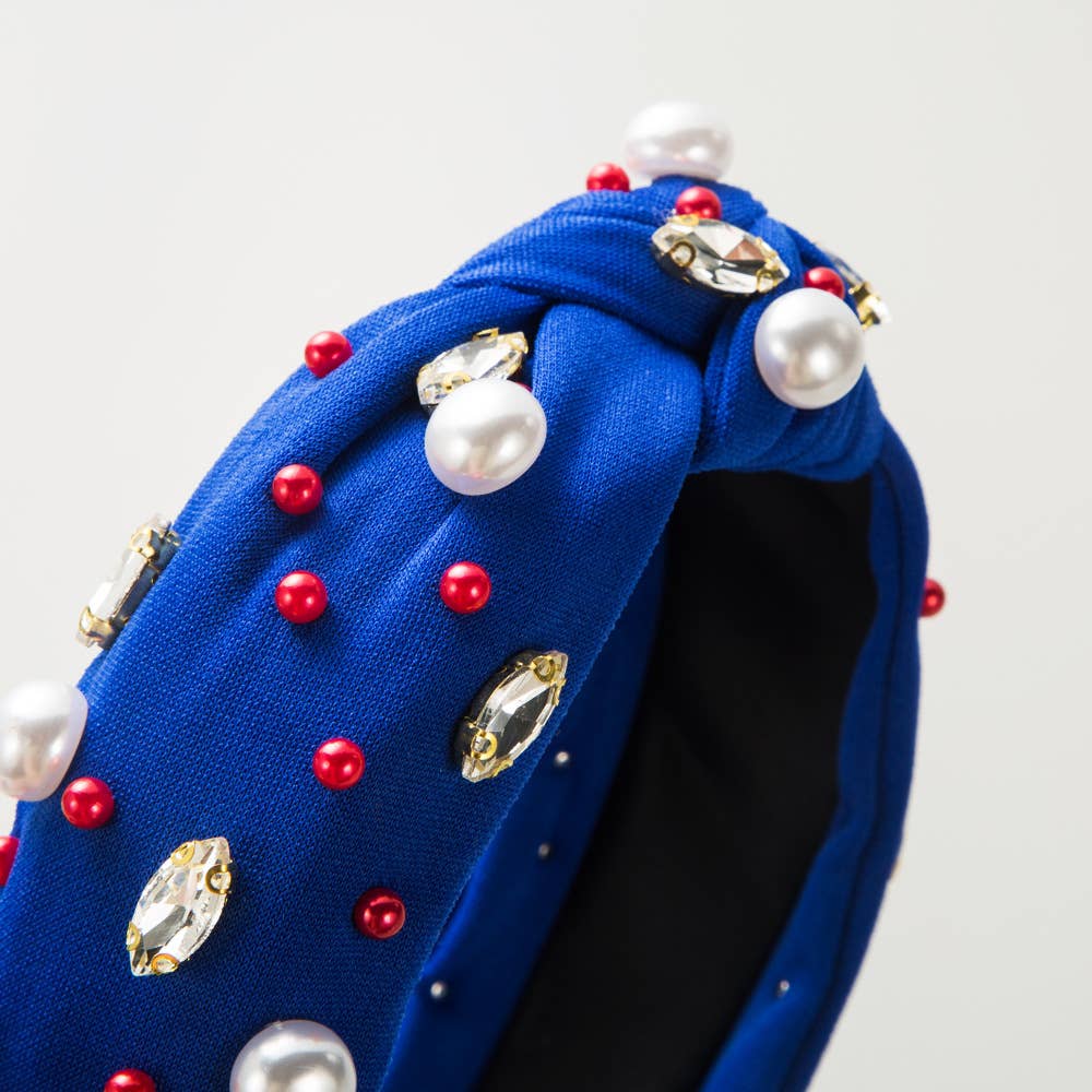 a blue hat with pearls and jewels on it