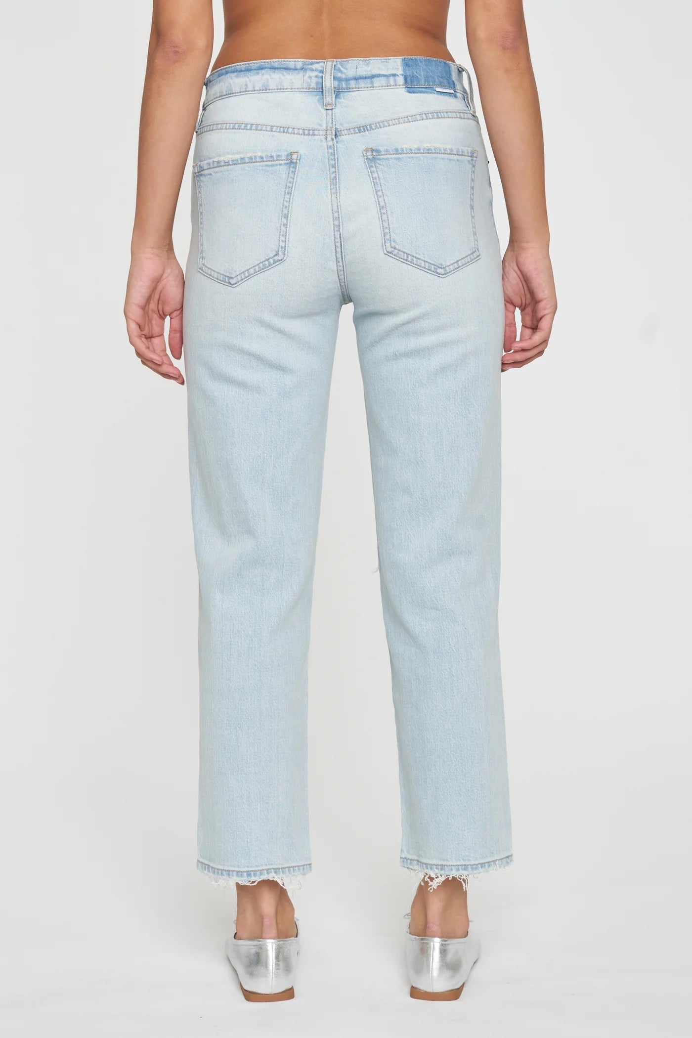 a woman wearing light blue jeans and silver heels