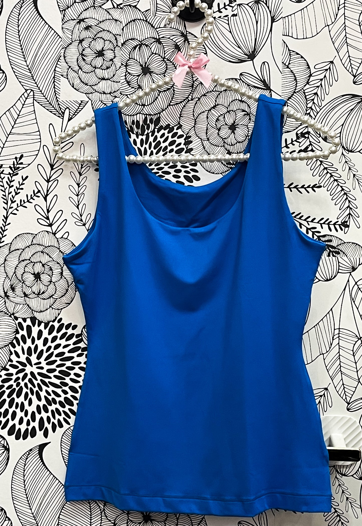 a blue top is hanging on a wall