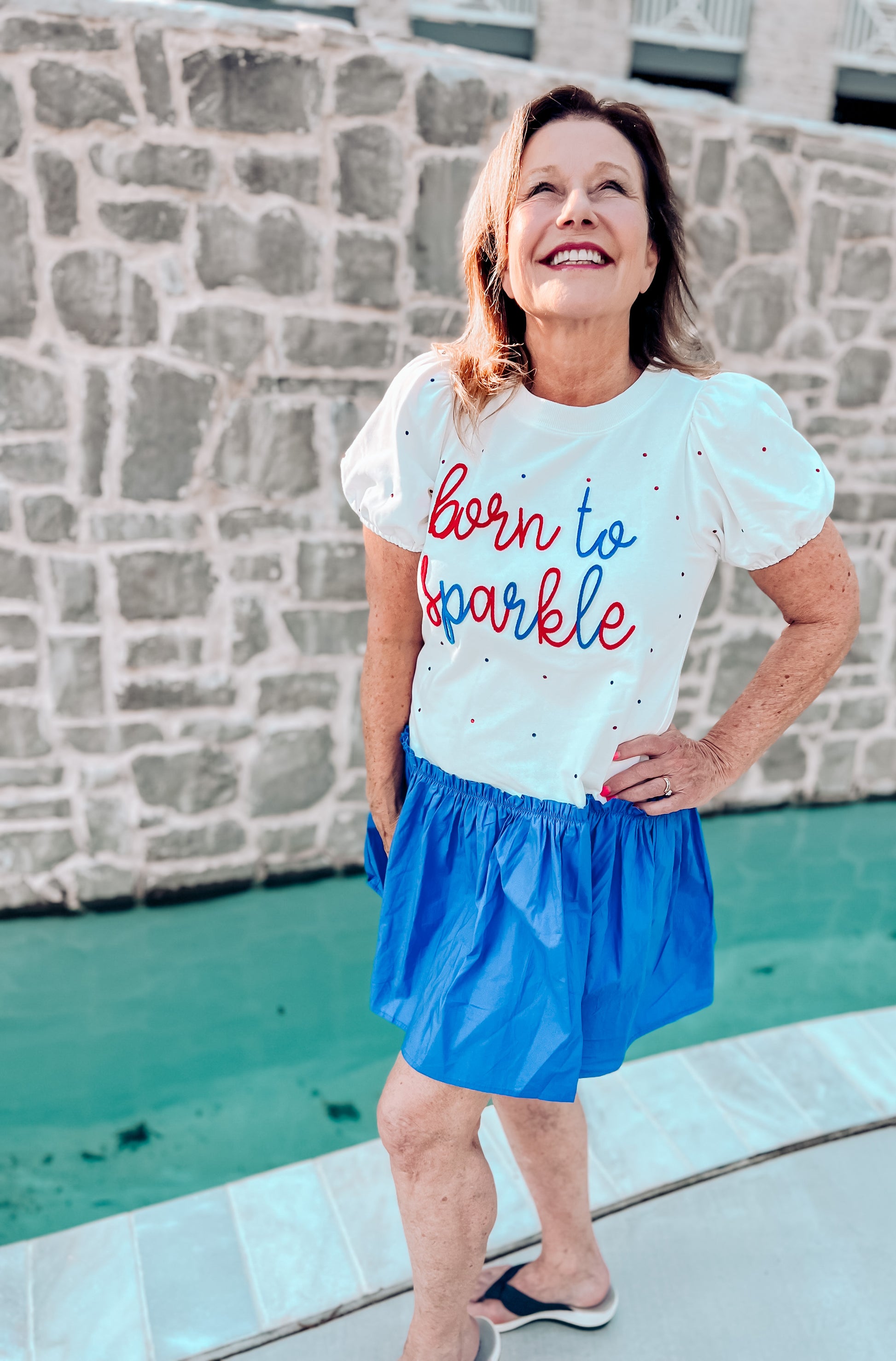 a woman wearing a shirt that says born to sparkle