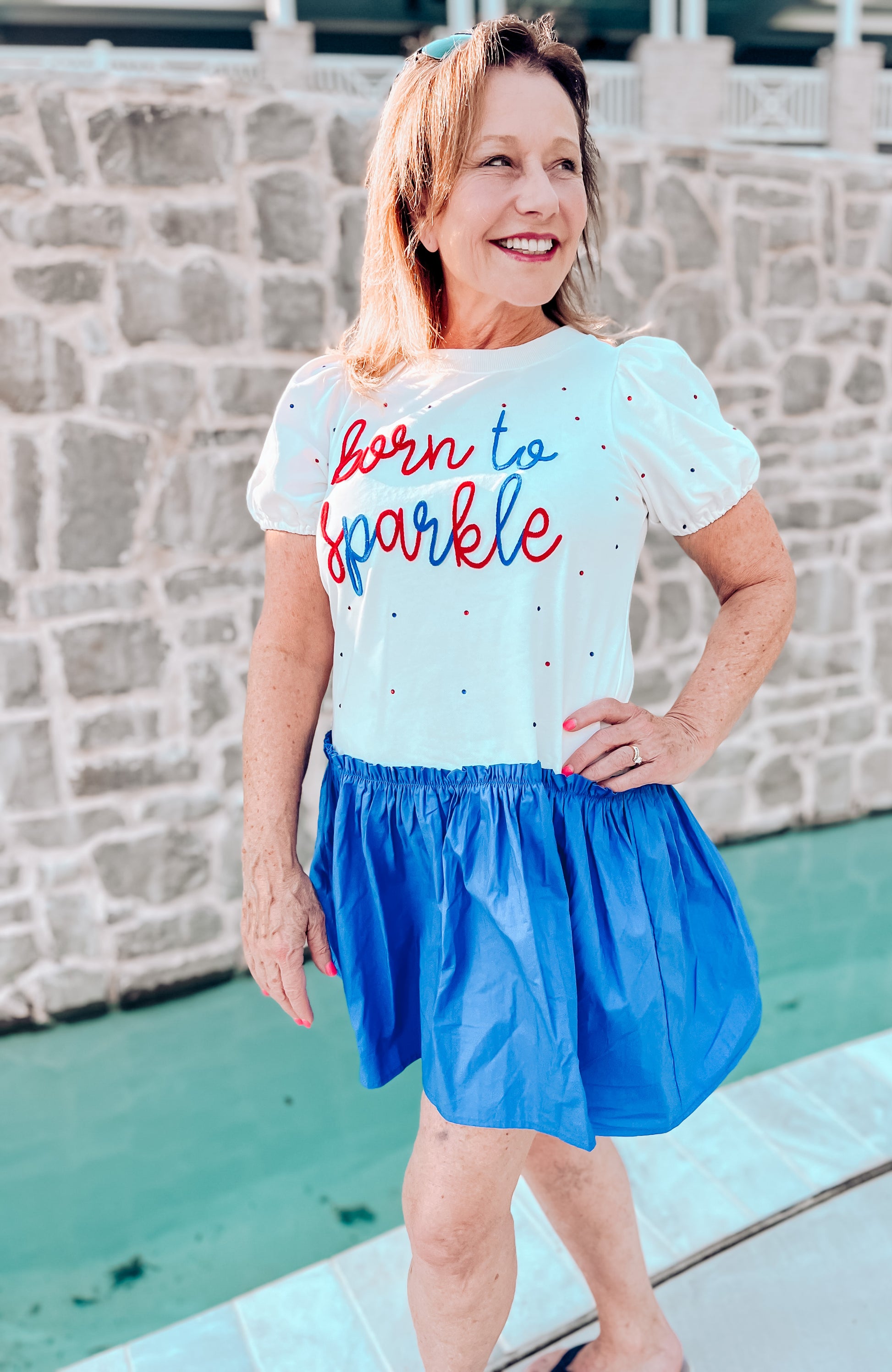 a woman wearing a t - shirt that says born to sparkle