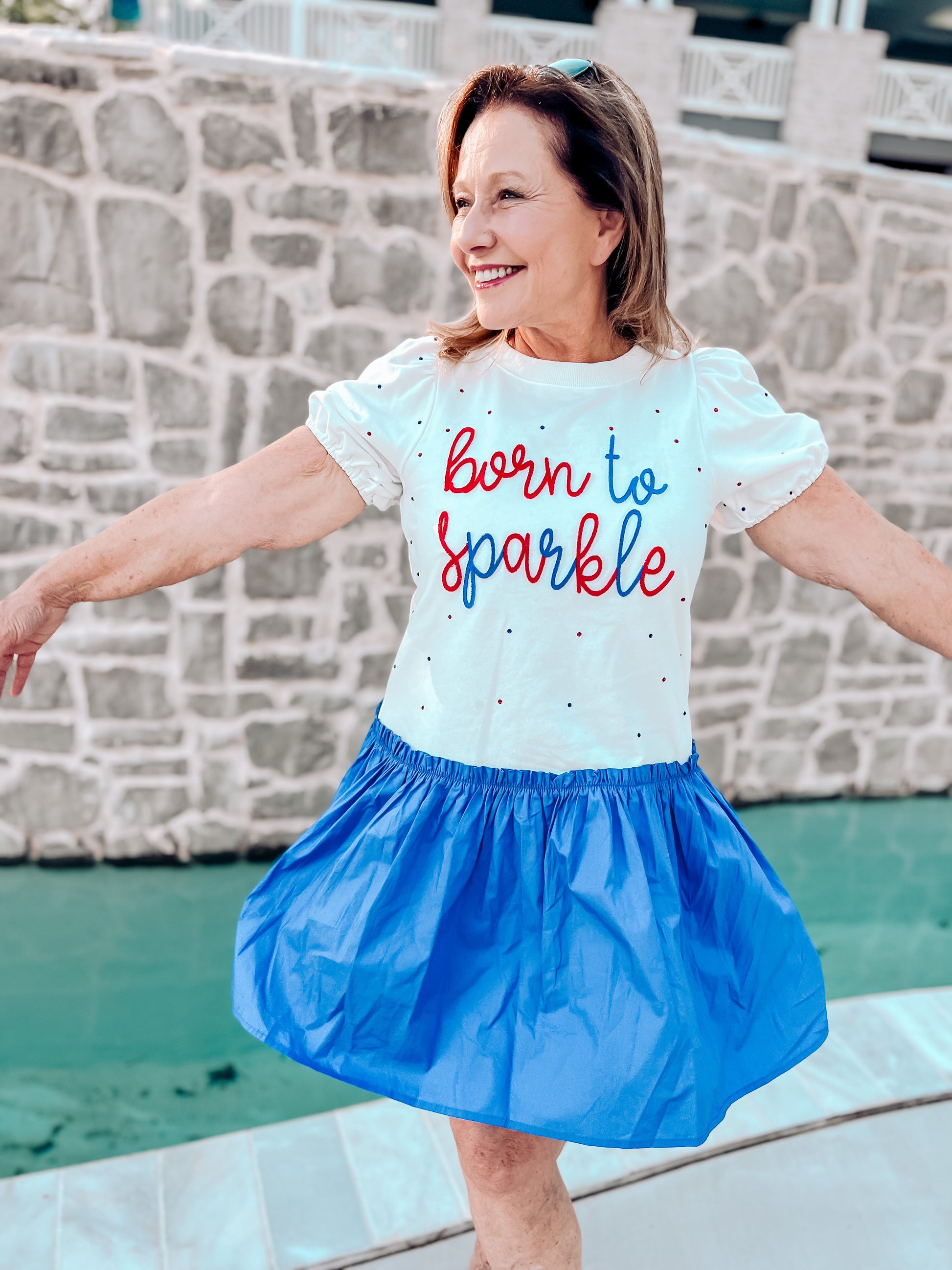 a woman in a blue and white dress is smiling