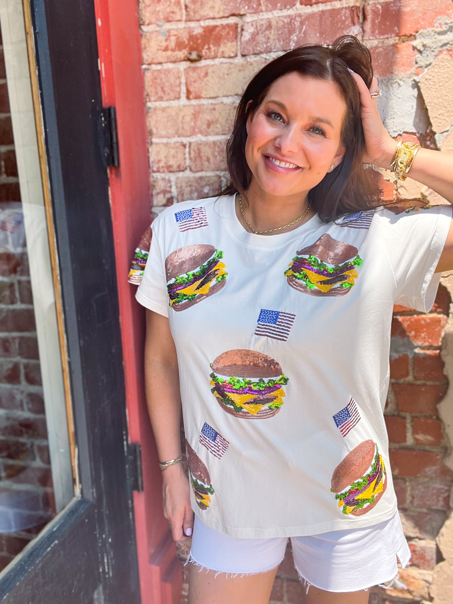 a woman leaning against a brick wall with a hamburger on it