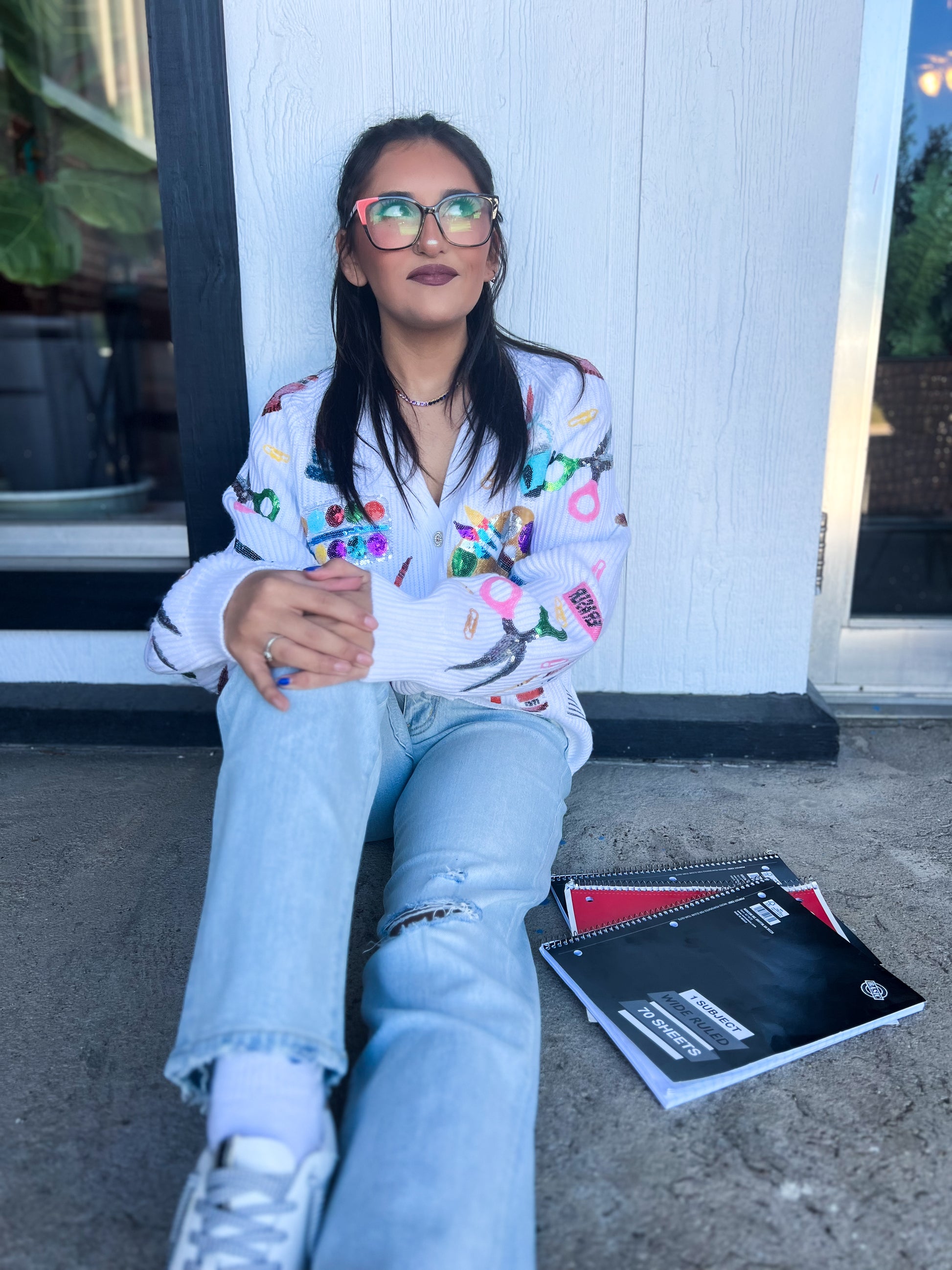 a woman sitting on the ground next to a book