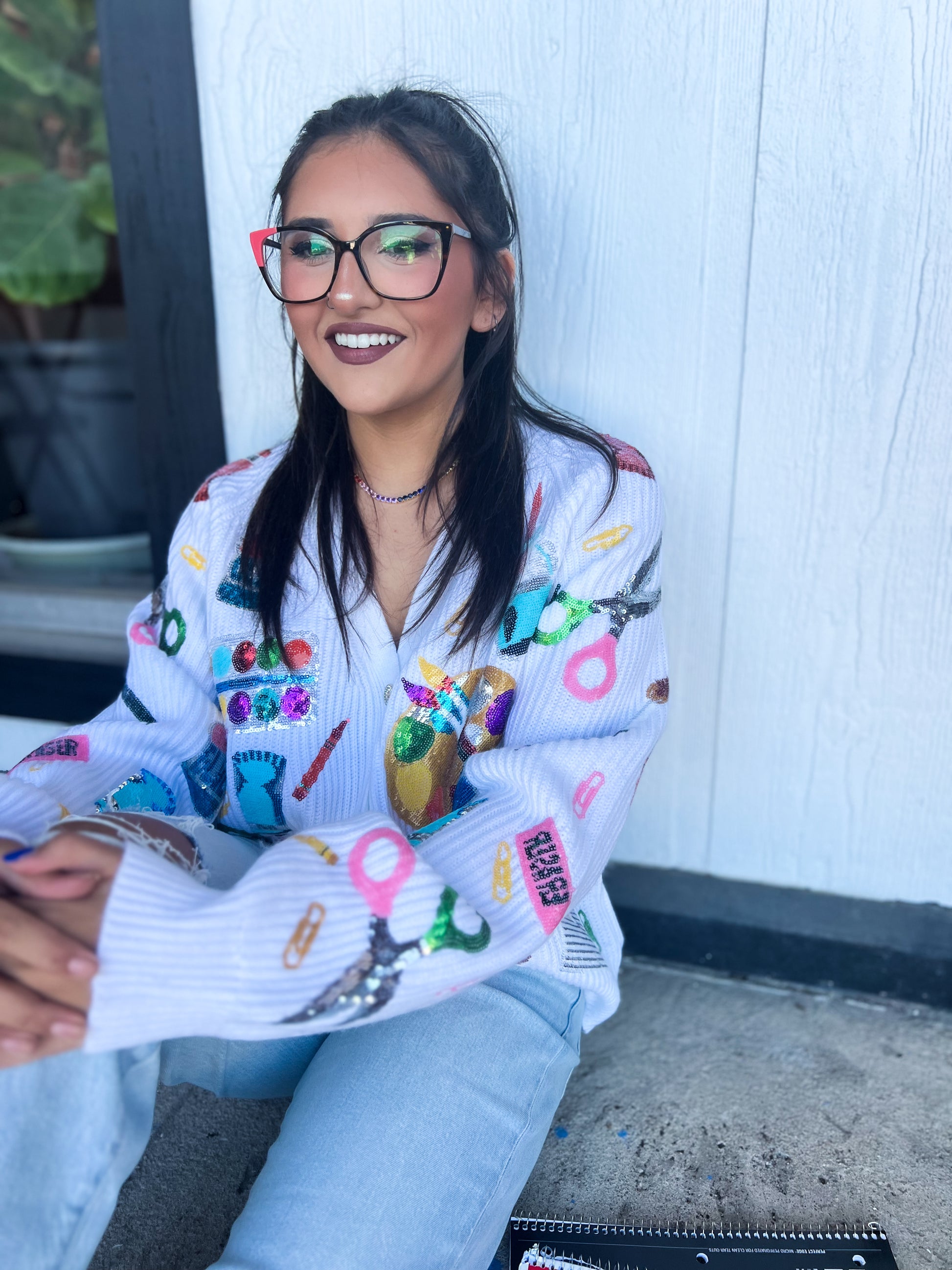 a woman wearing glasses sitting on the ground