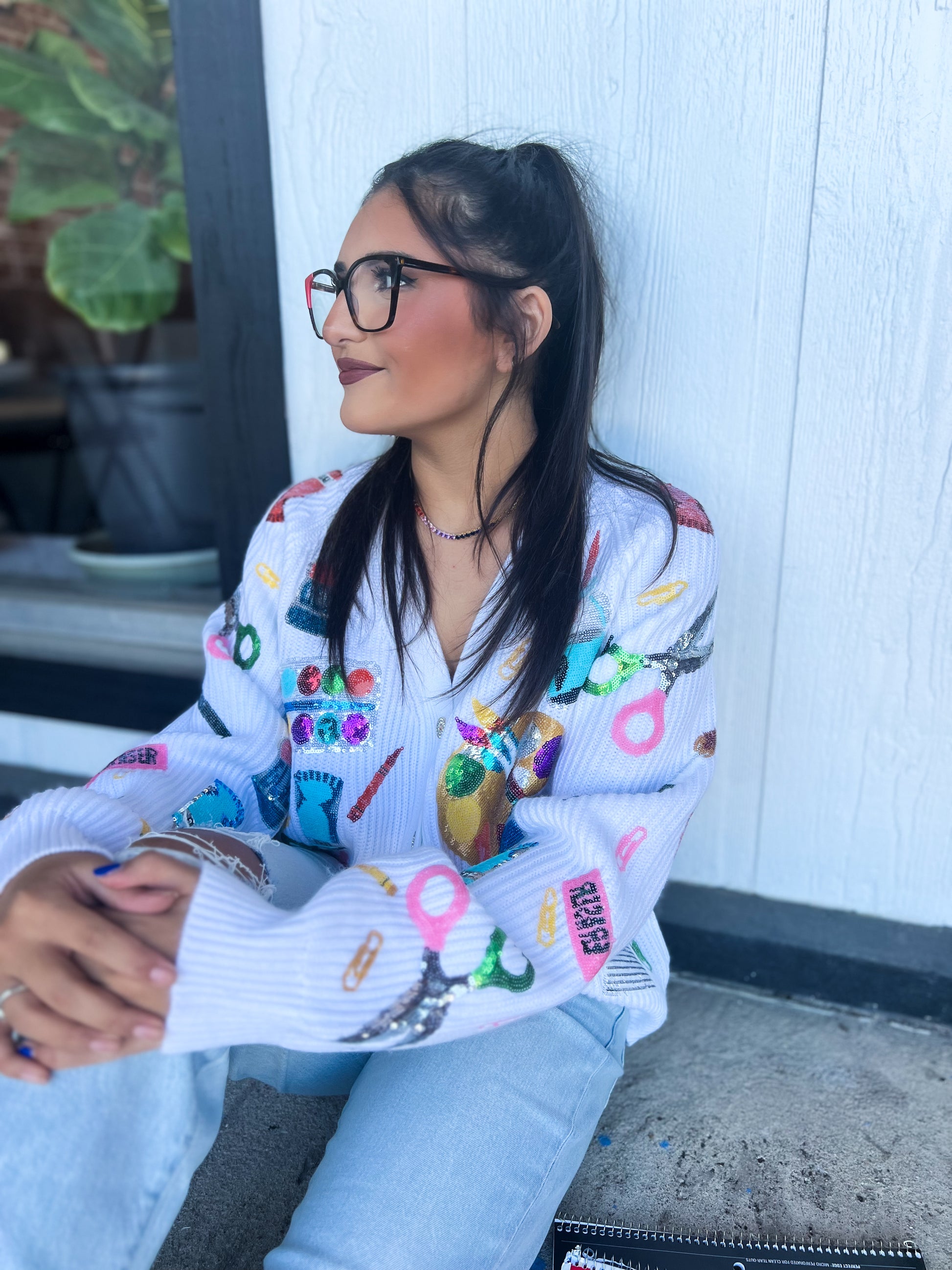 a woman sitting on the ground wearing glasses