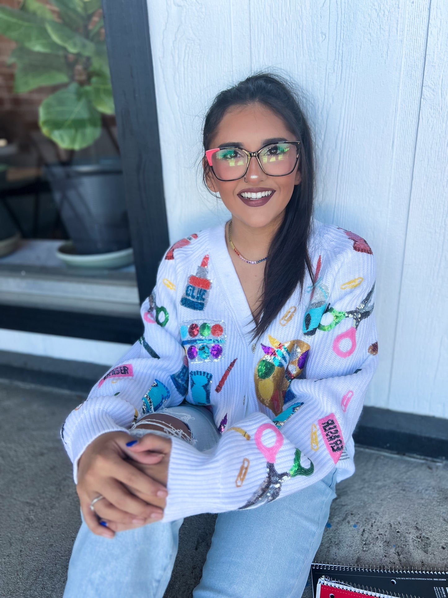 a woman wearing glasses sitting on the ground