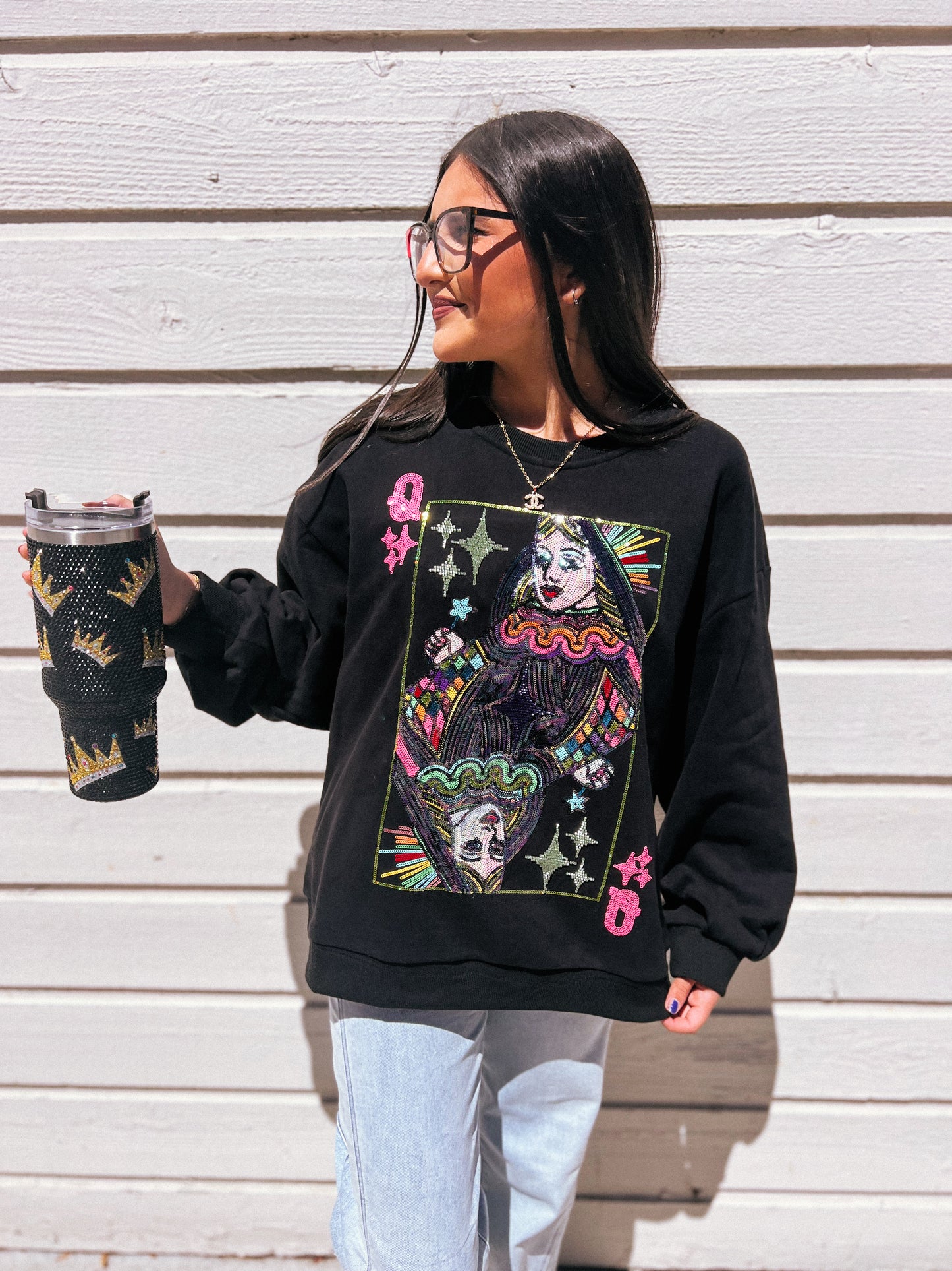 a woman wearing a black sweatshirt holding a black vase