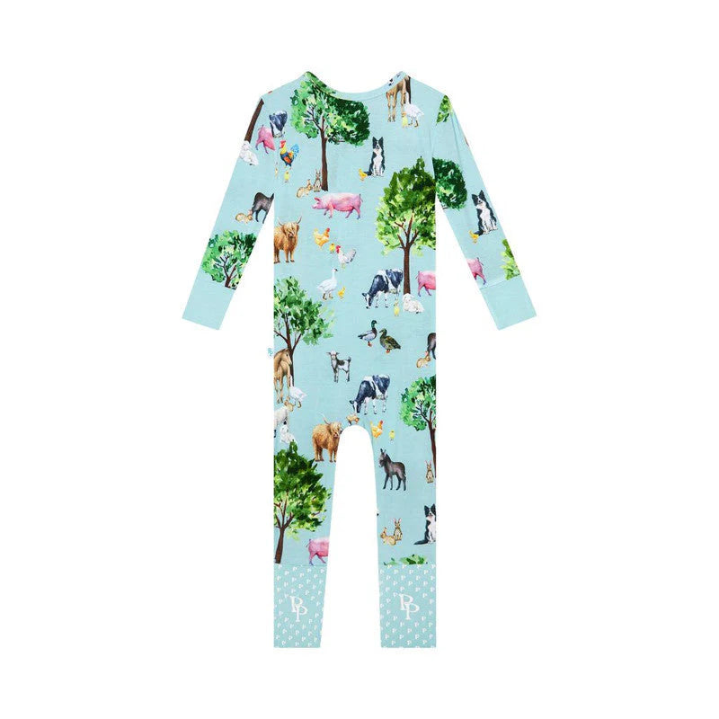 a baby's footless pajamas with horses and trees on it