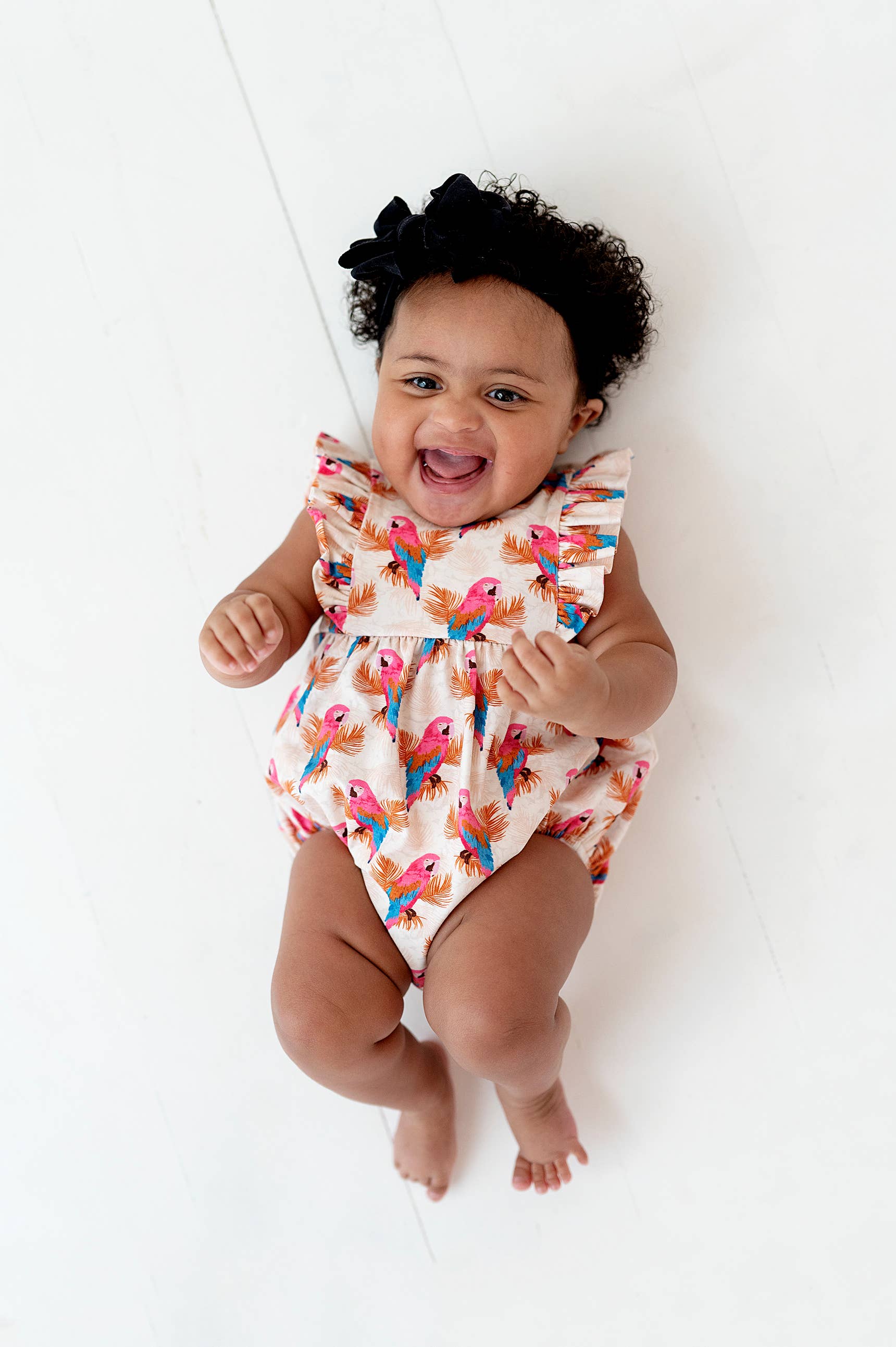 a baby is smiling while laying on the floor