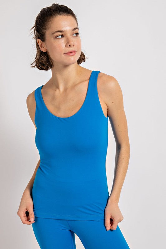 a woman in a blue tank top and leggings