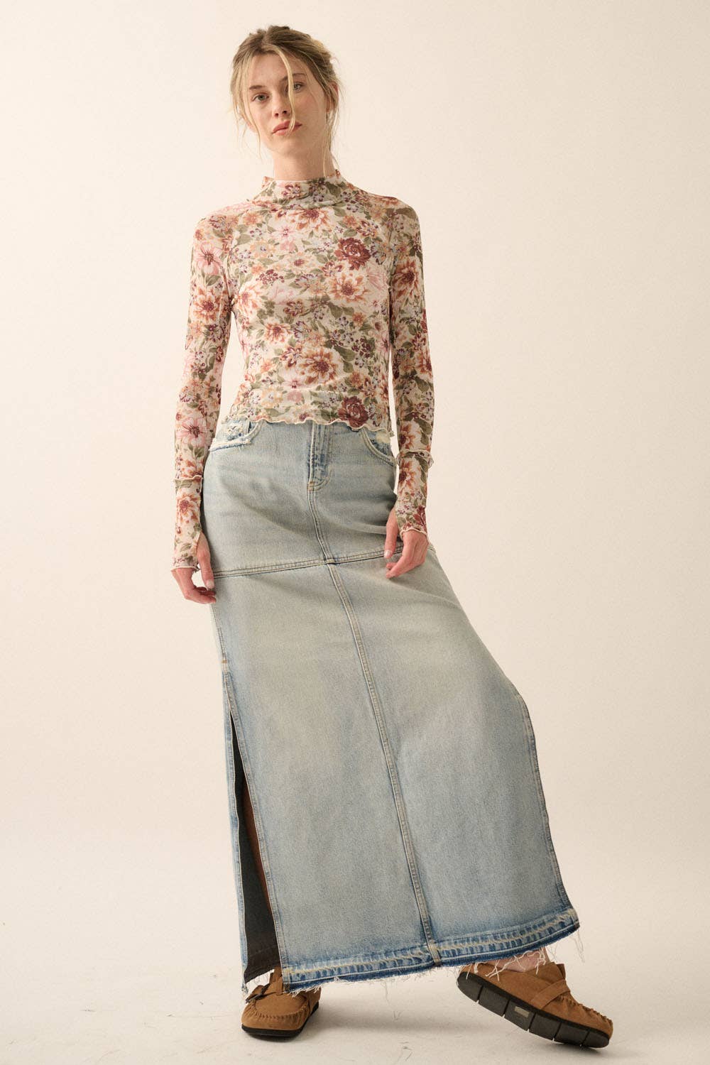 a woman in a floral top and denim skirt