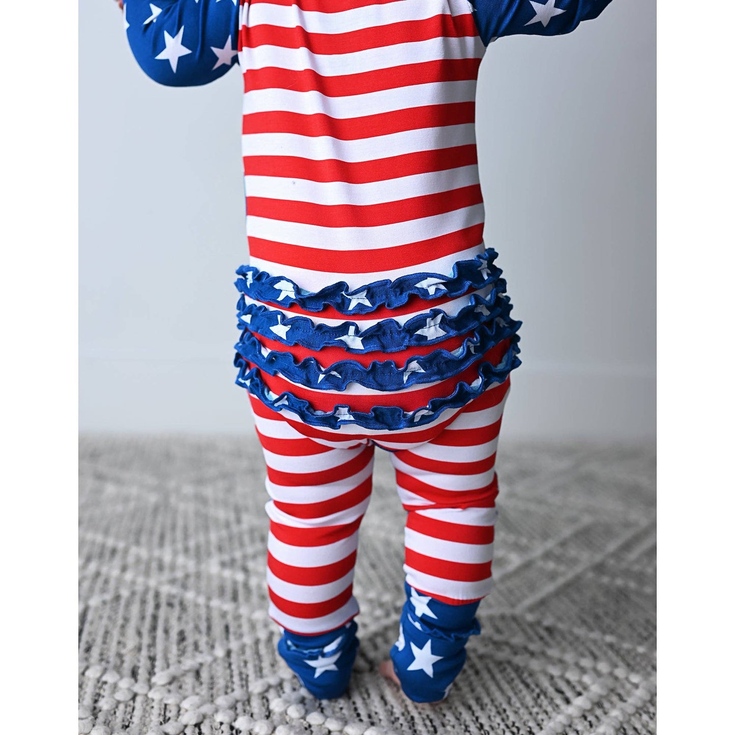 a baby in a red, white and blue outfit