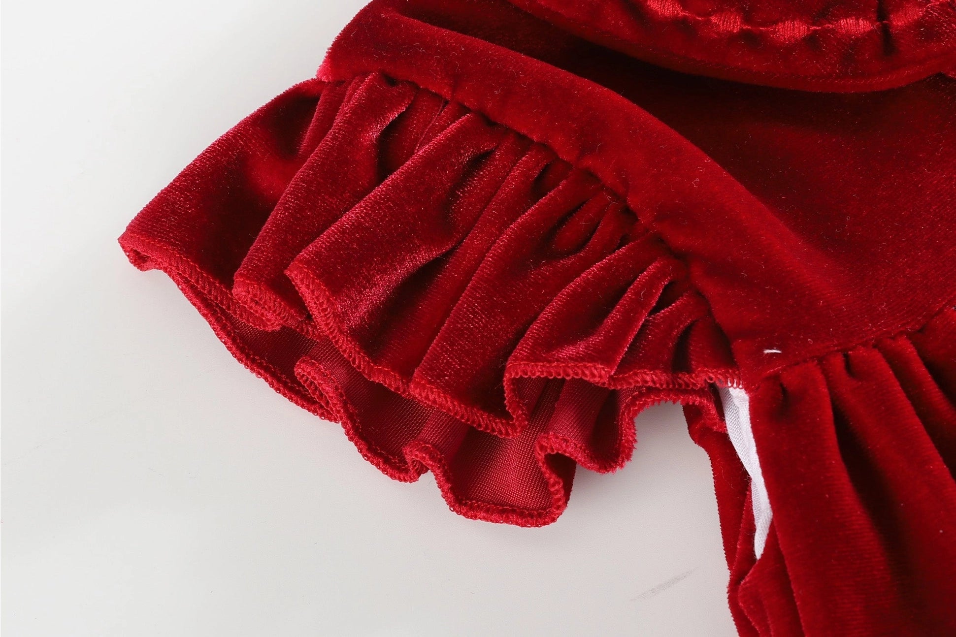 a close up of a red dress on a white surface