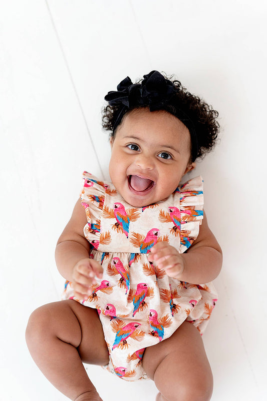 a baby is smiling while laying on the floor