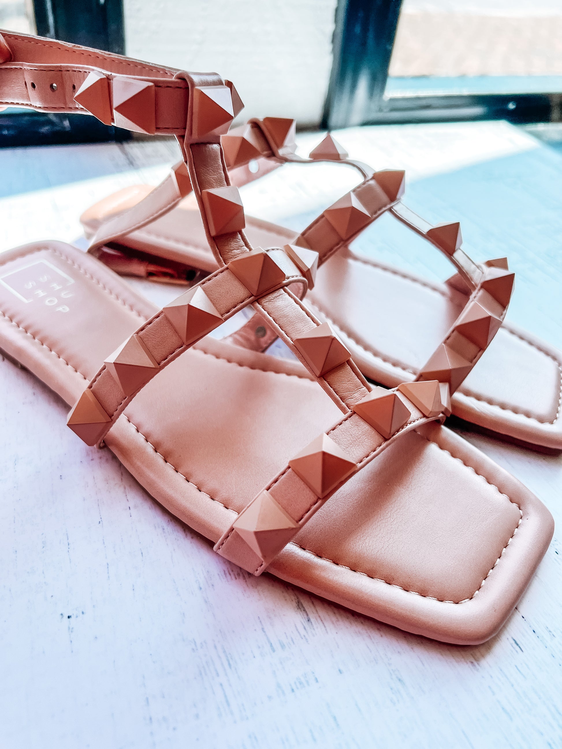 a pair of pink sandals sitting on top of a table